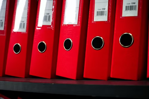 Red compliance binders representing DEA controlled substance recordkeeping requirements